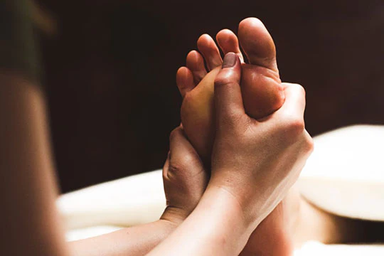 therapist providing foot massage, close up image